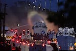 Police fire a water cannon towards rioters after they set fire to wheelie bins and removed a garden fence to use as a shield against the water cannon in Newtownabbey, Belfast, Northern Ireland, Wednesday June 10, 2026.