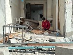 A man sits in the rubble of his destroyed home in Rafah as Palestinians return to the southern Gaza Strip city for the first time in months, after Israeli troops withdrew to the border, Jan. 20.