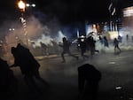 Demonstrators flee as police fire tear gas during clashes following the grand jury decision in the death of 18-year-old Michael Brown in Ferguson, Missouri, on November 24, 2014.