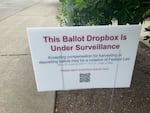Signs like this one at the Broadview library branch in north Seattle popped up at some King County ballot drop boxes in July. They prompted concerns about voter intimidation and ultimately an investigation by the King County Sheriff's Office. 