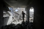 Palestinians look at the destruction after an Israeli strike on residential building in Rafah, Gaza Strip, Tuesday, May 7, 2024.