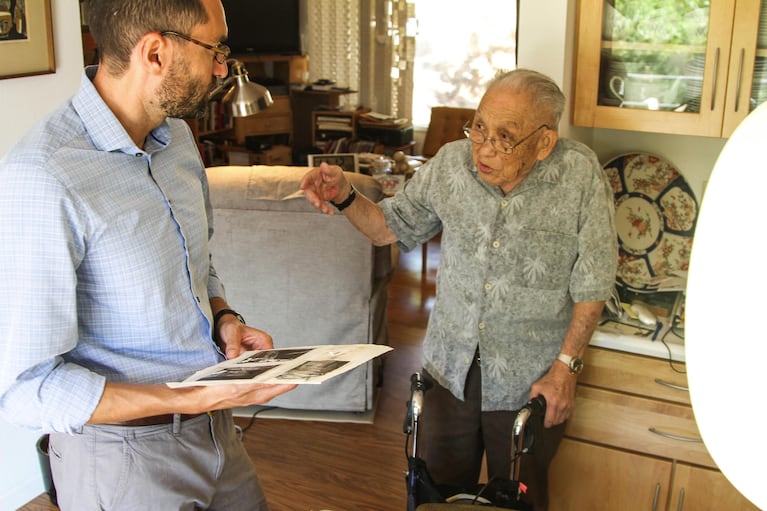 James Yamazaki explains post-WWII photographs from Nagasaki that Dave Miller looks through before the interview.