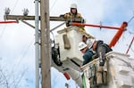 PGE contractors from DJ's Electrical in Portland repair a transformer box on a power pole on Southeast Madison Street near 17th Avenue in Portland, Feb. 16, 2021. Portland General Electric officials said post of its customers' power will be restored by Friday night.