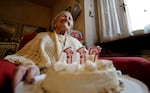 FILE- Emma Morano holds a cake with candles marking 117 years on the day of her birthday, Nov. 29, 2016, in Verbania, Italy.