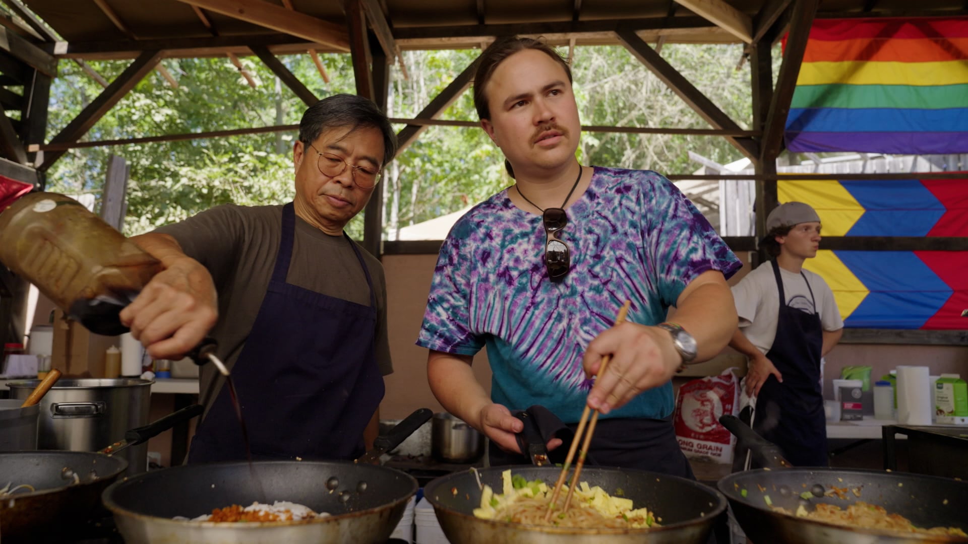 Saman Harnsongkram and his son Richard cook together at their booth, Bangkok Grill, at the Oregon Country Fair, July 14, 2024.