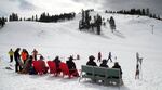 Parents relax toward the end of the ski day as kids squeeze in a few more runs.