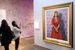 Attendees gaze at a painting of Henrietta Lacks at HBO's The HeLa Project Exhibit for The Immortal Life of Henrietta Lacks in 2017 in New York City.