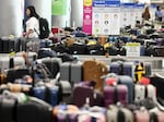 A traveler looks for baggage amid rows of unclaimed luggage at Los Angeles International Airport in June.