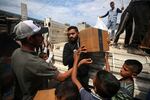 A Palestinian is carrying boxes of aid distributed before the Eid al-Fitr holiday, which marks the end of the Muslim holy fasting month of Ramadan, amid the ongoing conflict between Israel and Hamas, in Deir al-Balah, in the central Gaza Strip, on Monday.