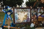 A framed picture is adorned with flowers and crosses at a memorial for the victims of the mass shooting at Robb Elementary School on June 25.