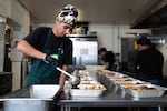 Milk Crate Kitchen volunteer Kiran Schurke portions meals for the nonprofit on Friday, Nov. 14, 2025 in Portland, Ore. The group delivers meals to community based organizations across Portland and prepares 100 meals for families delivered to their door or available for pick-up every other week.