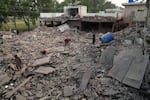 Members of media and local residents walk through the rubble of a building damaged by suspected Indian missile attack, in Muridke, a town in Pakistan's Punjab province, Wednesday, May 7.