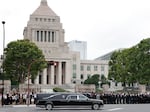 A hearse which carries the body of former Prime Minister Shinzo Abe, makes a brief visit to the House of Parliament after his funeral Tuesday, July 12, 2022, in Tokyo.