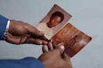 Travis Spencer holds family photographs of his older brother, Timothy Spencer.