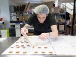 QUIN candy confectioner carefully spoons molten chai lollipops into their molds.