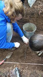 WOU undergrads Martha Kools and Taylor Maddox carefully clear away the soil around the leg of a skeletonized pig.