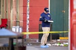 A person writes on a clipboard as he gathers evidence on the street.