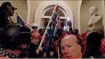 A red circle highlights the head of a man at the bottom of a screen filled with numerous people, many carrying U.S. flags or other flags.