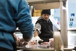 Iman Hussein helps with the meat cutting at Mingala Market in Portland, Ore. on Dec. 12, 2018.