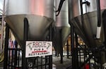 Gigantic stainless steel brewery vats tower the bottom level of Rogue’s headquarters in South Beach, where the company’s beers, ales and spirits are produced before they make their way to distributors in all 50 states and more than 50 countries.