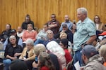 Pettit stands up in the middle of a crowded school auditorium and speaks into a microphone.