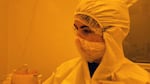 In this video still, WSU Vancouver grad student Zoe Templin works in a cleanroom in March to fabricate a new kind of honey-based computer component.