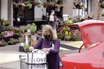 A woman wearing a face mask loads groceries into her car after shopping at a Zupan's grocery store in Portland, Ore., on Friday, May 21, 2021.