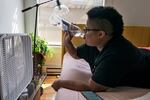 Katherine Morgan drinks water in front of a box fan while trying to stay cool in her downtown apartment without air conditioning on Thursday, Aug. 12, 2021, in Portland. People have headed to cooling centers as the Pacific Northwest began sweltering under another major, multi-day heat wave.