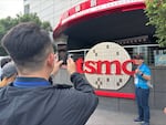 A tourist poses for a picture outside a TSMC building in Hsinchu, Taiwan.
