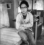 Bob Shimabukuro at home in 1983, sitting on one of the tables he built.