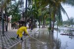 A man unclogs a drain in the aftermath of Hurricane Beryl, in Tulum, Mexico, Friday, July 5, 2024.