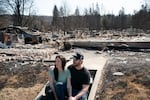 Melissa and Christopher Matthews in front of the remains of their home in Spokane on August 14, 2026. The Spokane Complex fires have caused over 900 structures to burn down.