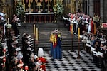 Members of the Royal family and guests sing as the coffin of Queen Elizabeth II, draped in the Royal Standard, lies by the altar.