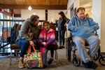Elaine Leonard adjusts the hair of her daughter, five-year-old Eliza Gamage, as they wait in the lobby for their turn to get food.