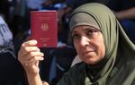 A Palestinian-German woman shows her German passport at the Rafah border crossing between the Gaza Strip and Egypt on Saturday. The crossing point remains closed, but is a potential route for foreign passport holders to leave Gaza, and for humanitarian supplies to enter as the Mideast crisis worsens.