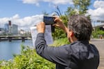 Sam Olbekson, citizen of the White Earth Nation of Minnesota Ojibwe, design project lead for Center for Tribal Nations, pauses to snap a photo of the Portland cityscape during a tour of the OMSI district.