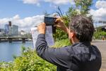 Sam Olbekson, citizen of the White Earth Nation of Minnesota Ojibwe, design project lead for Center for Tribal Nations, pauses to snap a photo of the Portland cityscape during a tour of the OMSI district.