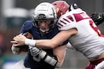Lake Oswego quarterback Casey Filkins (9) takes a hit from Central Catholic after running the ball. The Central Catholic Rams played the Lake Oswego Lakers at Hillsboro Stadium in Hillsboro, Oregon, on Dec. 7, 2019. The Rams defeated the Lakers 49-28.