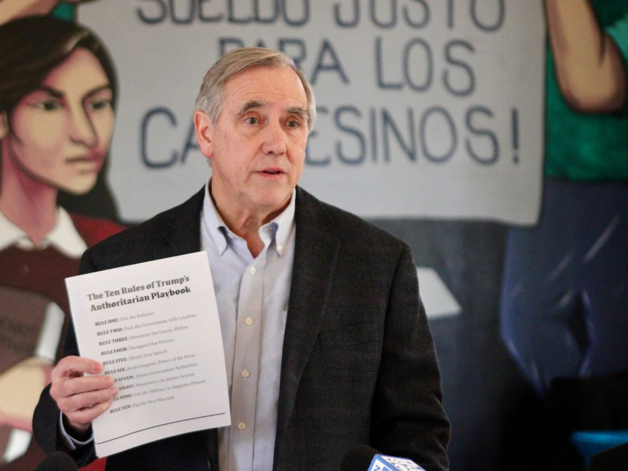 Sen. Jeff Merkley, D-Oregon, holds up a copy of his pamphlet about the authoritarian playbook in Woodburn, Ore., on Feb. 13, 2026.