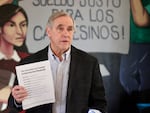 Sen. Jeff Merkley, D-Oregon, holds up a copy of his pamphlet about the authoritarian playbook in Woodburn, Ore., on Feb. 13, 2026.