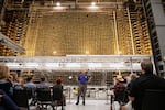 Visitors listen to guide Rick Bond as they stand before the front face of the plutonium reactor in the Hanford B Reactor in 2022. The B Reactor was the first full-scale plutonium production reactor in the world.