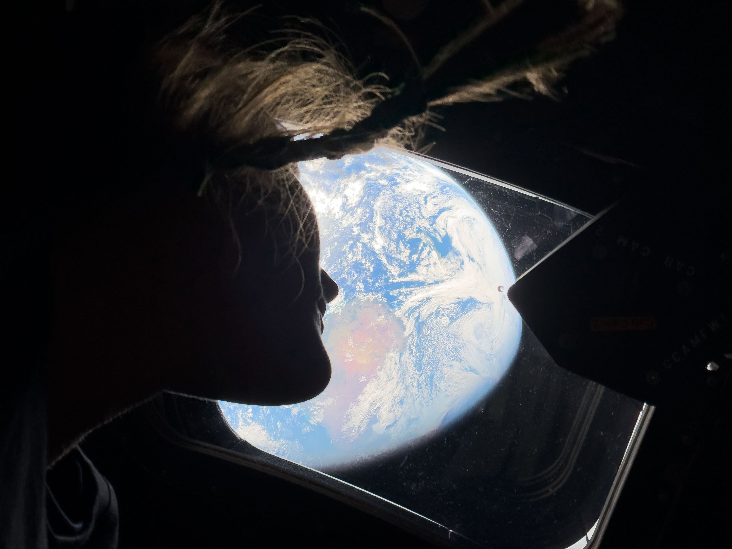 April 2: Mission specialist Christina Koch peers out one of the Orion spacecraft's main cabin windows, looking back at Earth, as the crew travels toward the moon.