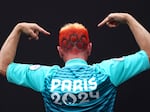 A spectator gestures as the Olympic rings are seen dyed into their hair prior to the opening ceremony of the Olympic Games Paris 2024 on July 26.
