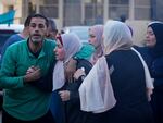 Palestinians mourn relatives killed in the Israeli bombardment of the Gaza Strip in front of the morgue in Deir al Balah, Sunday, Nov. 6, 2023.
