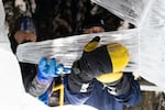 (from left) Dean DeMarais and Chris Foltz attach a mohawk spike made of ice in the 2023 World Ice Art Championships in Fairbanks, Alaska.