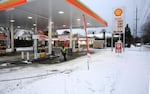 An employee at a Shell gas station clears the driveways leading to gas pumps.