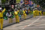 Pit crew members and officials are pictured during the IndyCar Freedom 250 Grand Prix auto race.