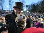 Groundhog Club handler A.J. Dereume holds Punxsutawney Phil, the weather-prognosticating groundhog, during the 138th celebration of Groundhog Day on Gobbler's Knob in Punxsutawney, Pa., on Friday.