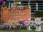 A memorial is seen surrounding the Robb Elementary School sign following the mass shooting at Robb Elementary School on May 26, 2022 in Uvalde, Texas.