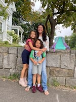 Jennifer Hensel waits for the school bus with her 8-year-old daughter, Imogen, and her 6-year-old son, Owen, on the first day of school this year. They share hugs, kisses, excitement and still some anxiety 10 years after the shooting.